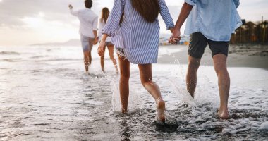 Bir grup arkadaş gün batımında sahilde eğleniyorlar..