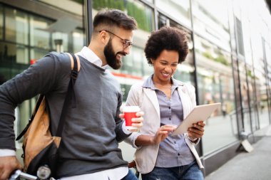 İş adamları şehirde dijital tablet kullanarak kahve molası veriyorlar.