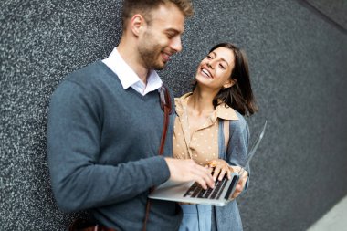 Dışarıda dizüstü bilgisayar kullanan mutlu kadın ve erkek. Seyahat, iş, teknoloji, insanlar eğlence kavramı