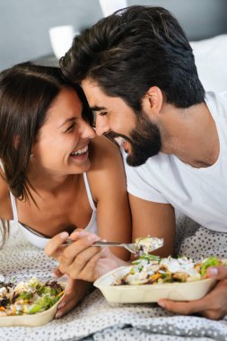 Romantik mutlu çift yatakta kahvaltı yapıyor. Aşk, insanlar, yemek konsepti