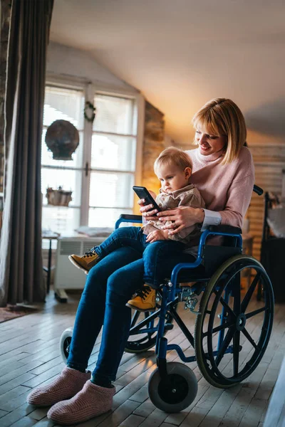 自宅で子供と遊んでいる車椅子で障害のある幸せな笑顔の母親 障害のある母親としての概念 — ストック写真