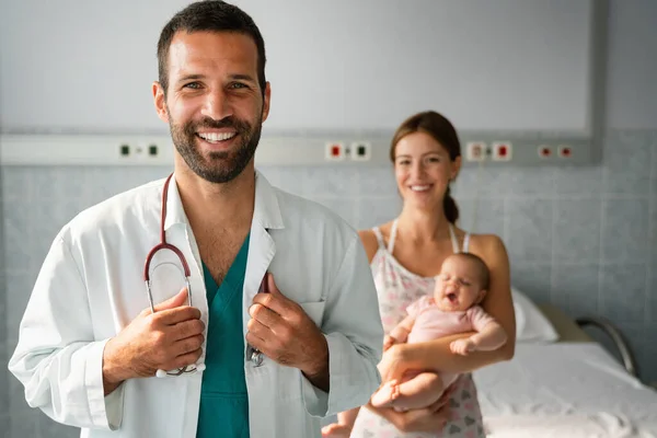 クリニックで母親と赤ちゃんの子供を持つハンサムな医師小児科医 子供の概念 — ストック写真