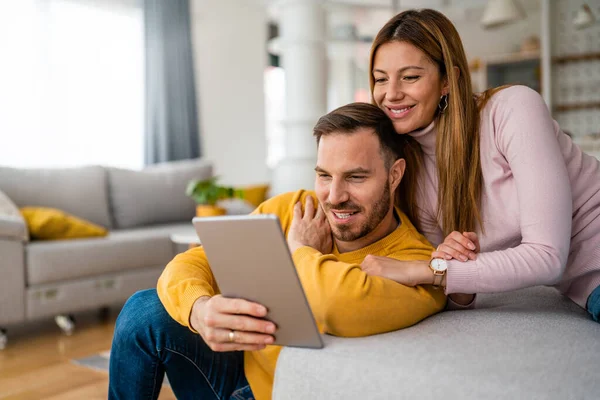 Casal Apaixonado Abraçando Usando Tablet Juntos Casa — Fotografia de Stock