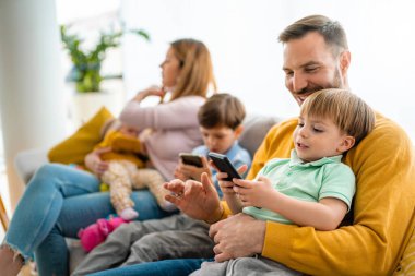 Evde oynayan ve sarılan çocuklu mutlu bir aile. Mutluluk, insanlar, ebeveynlik, çocukluk kavramı.
