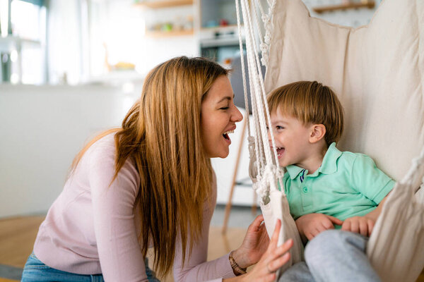 Happy family. Little boy having fun with his mother at home. Single parenting, happiness concept.