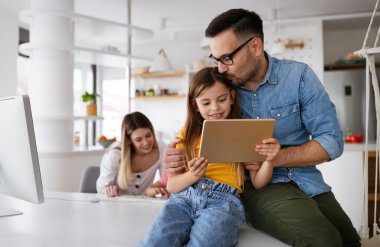 Tecrit ve çevrimiçi okul, teknoloji konsepti. Ebeveynler çocuklarına evde online ders çalışmaları için yardım ediyor.