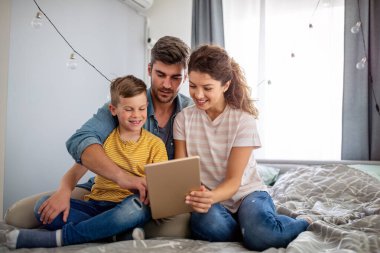 Mutlu aile evde teknoloji aletlerini birlikte kullanıyor. Halk, eğitim kavramı.