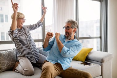 Heyecanlı olgun çift evde eğleniyor. Kıdemli eş ve koca hafta sonunu birlikte geçirmek, eğlenceli aktiviteler.