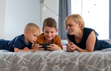 Teknolojiye bağımlı aile ve çocuklar dijital cihazlar kullanıyor. Aşırı sosyal medya, internet bağımlılığı kavramı