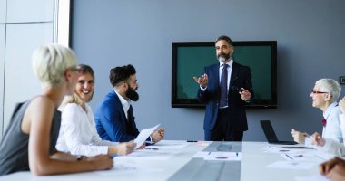 Ofiste takım olarak çalışan bir grup iş adamı.