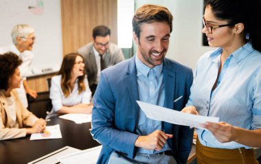 Çeşitli iş ortakları toplantıda belge ve fikirleri tartışıyor