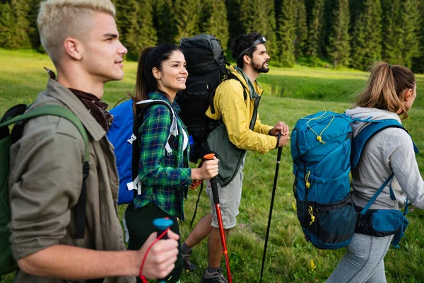 Trekking, hiking, camping and wild life concept. Group of friends walking and having fun together in nature