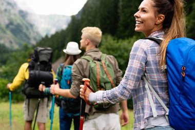 Sırt çantalı bir grup arkadaş dağda yürüyüş yapıyor. Trekker, spor, yürüyüş ve seyahat konsepti