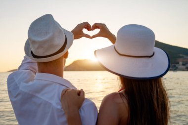 Güzel plajda, yaz tatilinde yürüyen romantik bir çift.