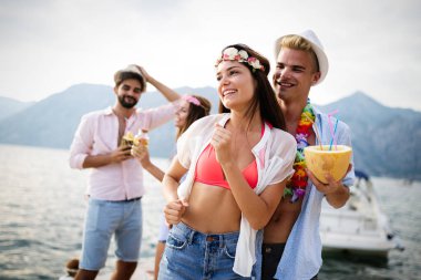 Bir grup arkadaş sahilde dans edip eğleniyorlar. Plajda yaz tatili partisi