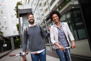 Şehirde elektrikli scooter ve bisiklet kullanan mutlu bir çift. Sıfır emisyonlu yeşil eko enerji kavramı