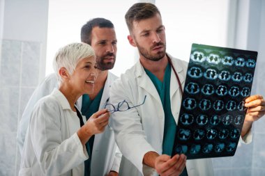 Bir grup doktor tomografiye bakıyor, teşhis koymak için hastanede MRI taraması yapıyorlar.