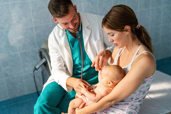 小児科医の母親が検査するために赤ん坊を抱えている 人々の医療概念 — ストック写真
