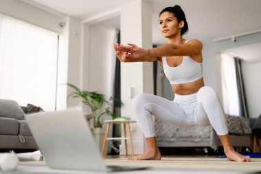 Evde egzersiz yapan güzel bir genç kadın. Fitness, sağlıklı yaşam tarzı, spor konsepti