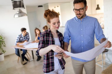 Ofisteki iş arkadaşlarıyla birlikte çalışırken analitik rapor sunan başarılı iş adamları