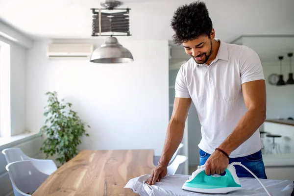 Feliz Joven Guapo Afroamericano Hombre Planchando Ropa Casa — Foto de Stock