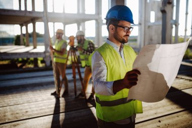 İnşaat mühendislerinden oluşan bir ekip inşaat alanında birlikte çalışıyor.