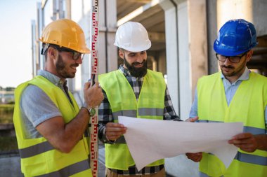 İnşaat mühendislerinden oluşan bir ekip inşaat alanında birlikte çalışıyor.