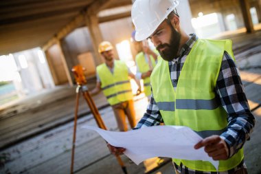 İnşaat mühendislerinden oluşan bir ekip inşaat alanında birlikte çalışıyor.