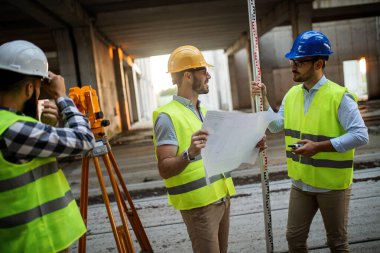 İnşaat mühendislerinden oluşan bir ekip inşaat alanında birlikte çalışıyor.