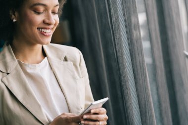 Akıllı telefon kullanan başarılı bir iş kadınının portresi. Mutluluk, iş, teknoloji kavramı.