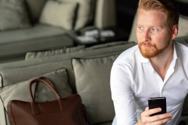 Akıllı telefon kullanan başarılı genç bir iş adamı.