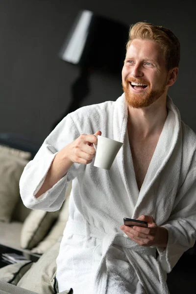 若い男でバスローブを着たコーヒーを飲んでホテル スパセンター — ストック写真