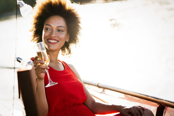 Summer lifestyle fashion portrait of young stylish black woman with drink