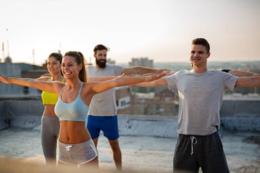 Bir grup zinde insan çatıda antrenman yapıyor.