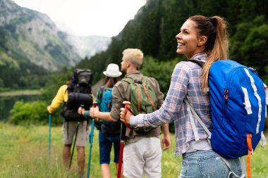 İnsanlar yürüyüş yapıyor. Bir grup mutlu yürüyüşçü arkadaş, açık hava aktivitelerinin bir parçası olarak yürüyüş yapıyorlar.