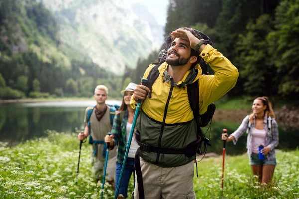 Group of young friends hiking in countryside. Multiracial happy people travelling in nature