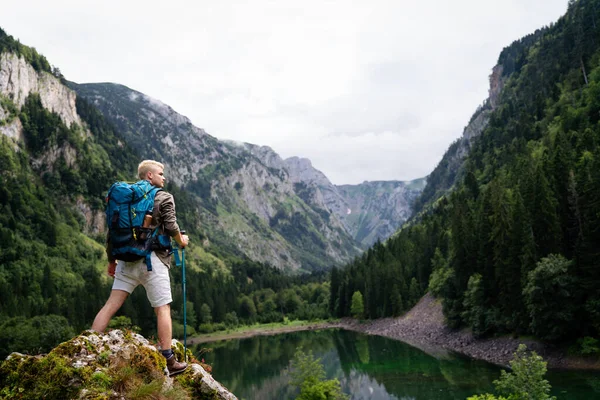 Sırt çantasıyla dağlarda gezen mutlu bir adam.