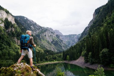 Sırt çantasıyla dağlarda gezen mutlu bir adam.
