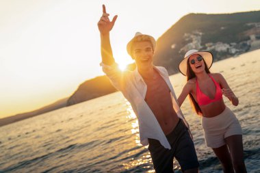 Kumsalda aşık çekici genç bir çift, yaz tatilinin tadını çıkarıyor, seyahat ediyor.