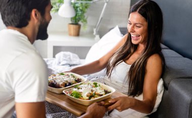 Mutlu adam kahvaltıyı yatağındaki güzel kız arkadaşına getiriyor.