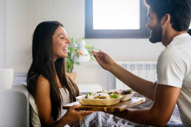 Mutlu adam kahvaltıyı yatağındaki güzel kız arkadaşına getiriyor.