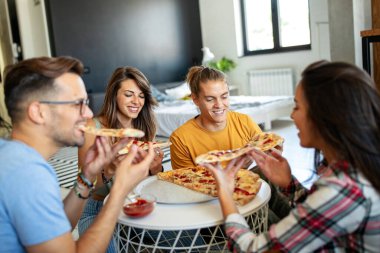 Bir grup mutlu arkadaş evde parti veriyor, pizza yiyor ve eğleniyorlar..