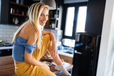 Evde uzun sarı saçlı, güzel, şehvetli bir kadının portresi.