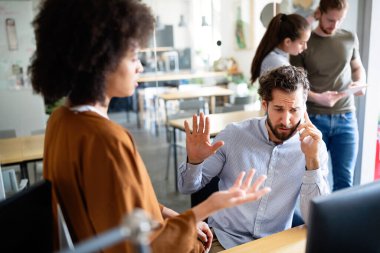 Ofiste çalışan, cep telefonuyla konuşan stresli genç bir iş adamı. Yoğun bir gün, iş, ofis, çalışan kavramı
