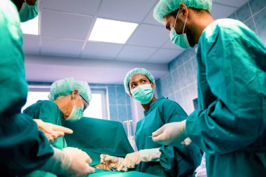Bir grup cerrah hastanedeki ameliyathanede çalışıyor.
