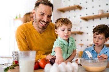 Mutfakta mutlu bir aile birlikte yemek pişiriyor. Evde sağlıklı yiyecekler..