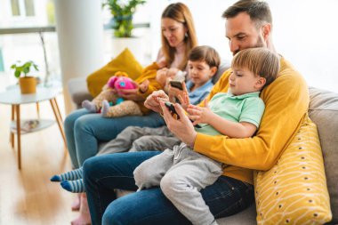 Evde oynayan ve sarılan çocuklu mutlu bir aile. Mutluluk, insanlar, ebeveynlik, çocukluk kavramı.