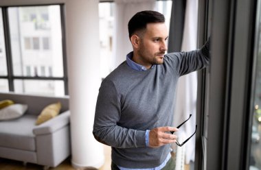 Evde dinlenen ve geleceği düşünen bir adamın portresi.