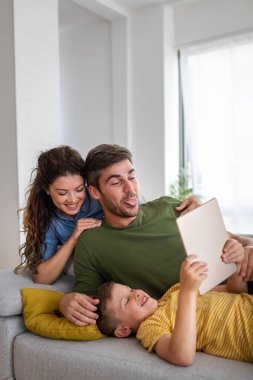 Mutlu aile evde teknoloji aletlerini birlikte kullanıyor. Halk, eğitim kavramı.