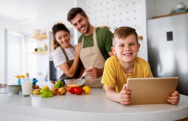 Mutfakta mutlu bir aile birlikte yemek pişiriyor. Evde sağlıklı yiyecekler..